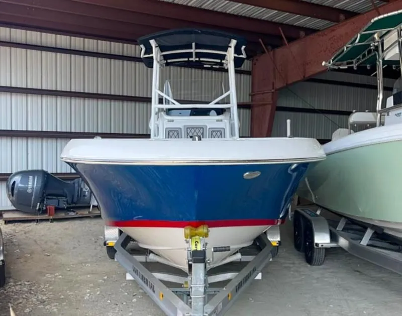 Slide: The Image of 2024 Wellcraft 202 Fisherman boat in storage, blue hull, on a trailer. - 1