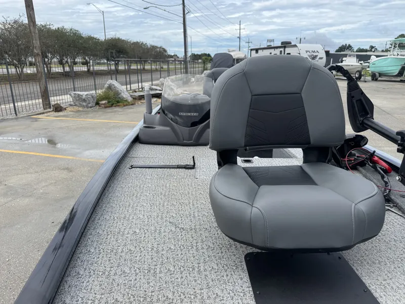Slide: The Image of 2024 Tracker Pro 170 boat with gray seating, parked outdoors on a cloudy day. - 7