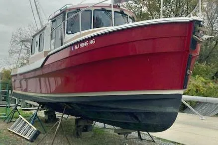The Image of 2016 Ranger Tugs R-31 boat in red, docked on land. - 0