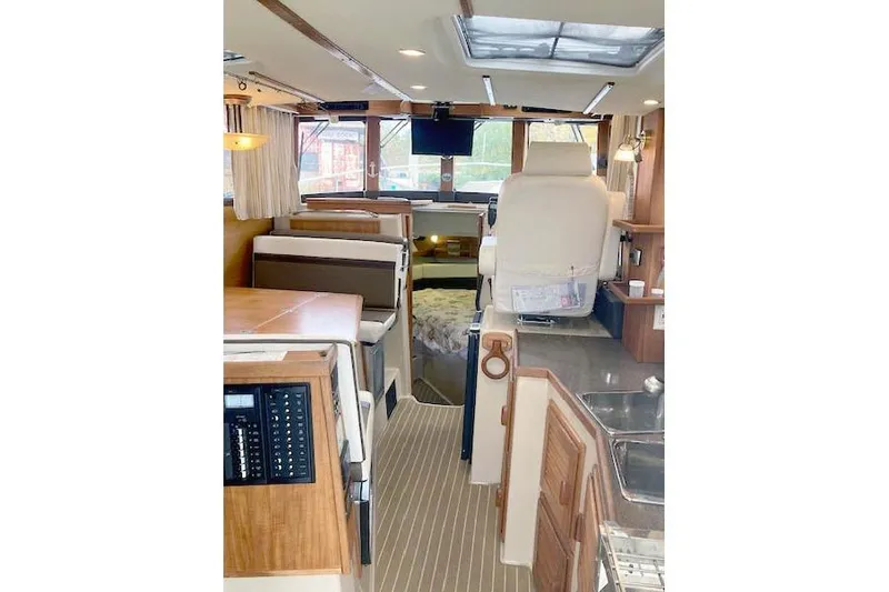 Slide: The Image of Interior of 2016 Ranger Tugs R-31 boat with seating, helm, and wood accents. - 14