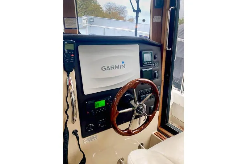 Slide: The Image of 2016 Ranger Tugs R-31 helm with Garmin navigation system and wooden steering wheel. - 18