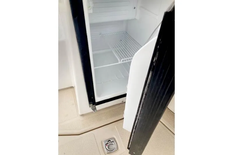 Slide: The Image of Open refrigerator on 2016 Ranger Tugs R-31 boat, showing empty interior and wire shelf. - 20