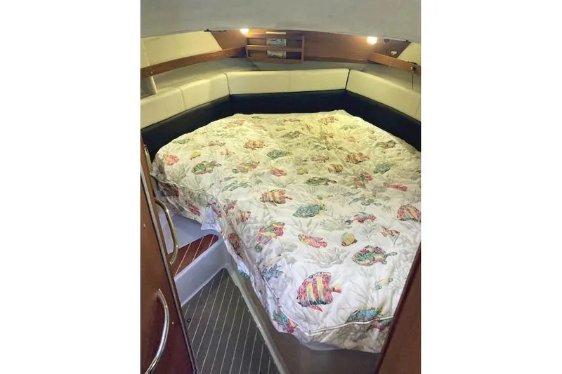 Slide: The Image of 2016 Ranger Tugs R-31 cabin interior with a cozy bed and nautical-themed bedding. - 29