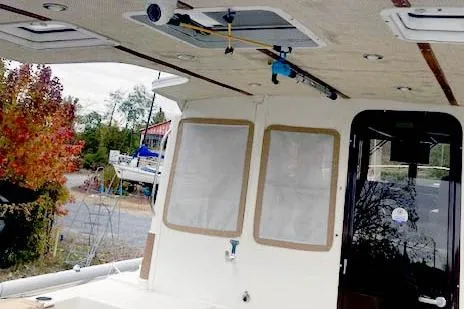 Slide: The Image of 2016 Ranger Tugs R-31 boat interior with fishing rod storage and outdoor view. - 6