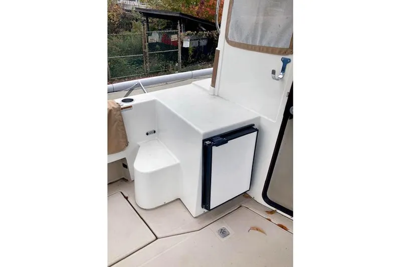 Slide: The Image of 2016 Ranger Tugs R-31 boat interior with compact fridge and seating area. - 8