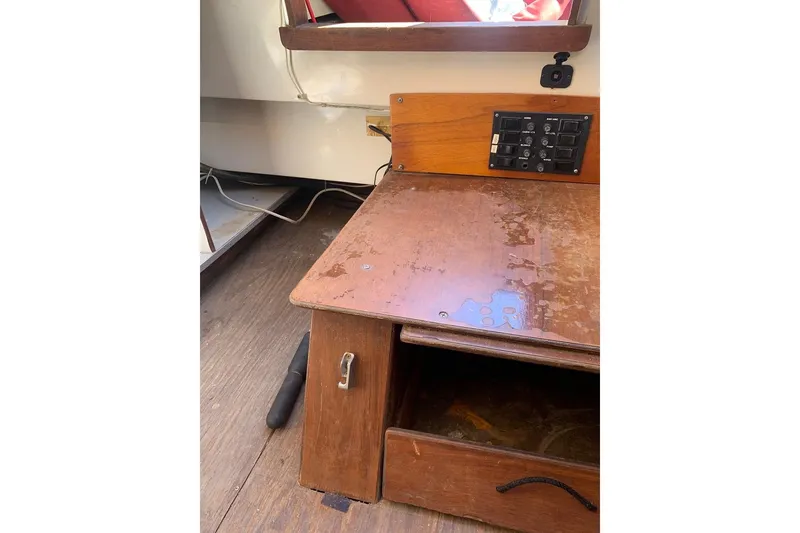 Slide: The Image of Interior of a 1986 Rhodes 22 sailboat with wooden desk and control panel. - 16