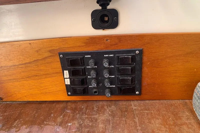 Slide: The Image of Control panel on a 1986 Rhodes 22 boat, featuring switches and labels. - 17
