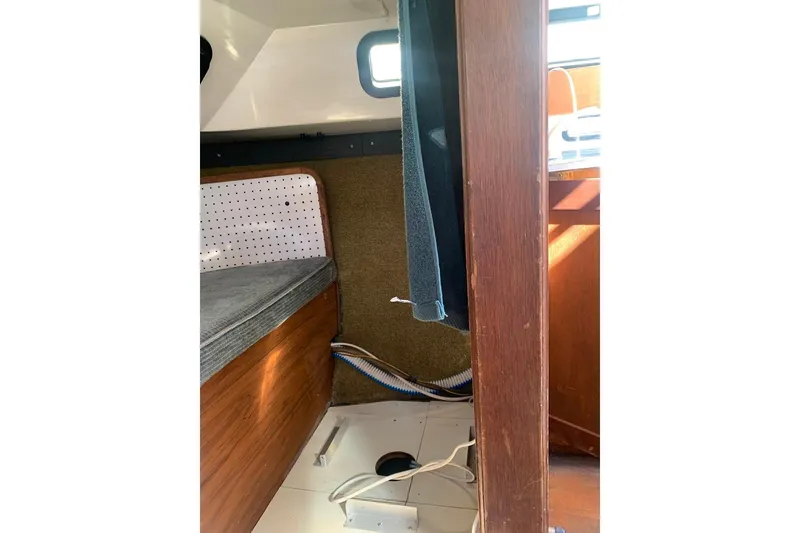 Slide: The Image of Interior of 1986 Rhodes 22 sailboat, featuring wooden paneling and compact cabin space. - 18