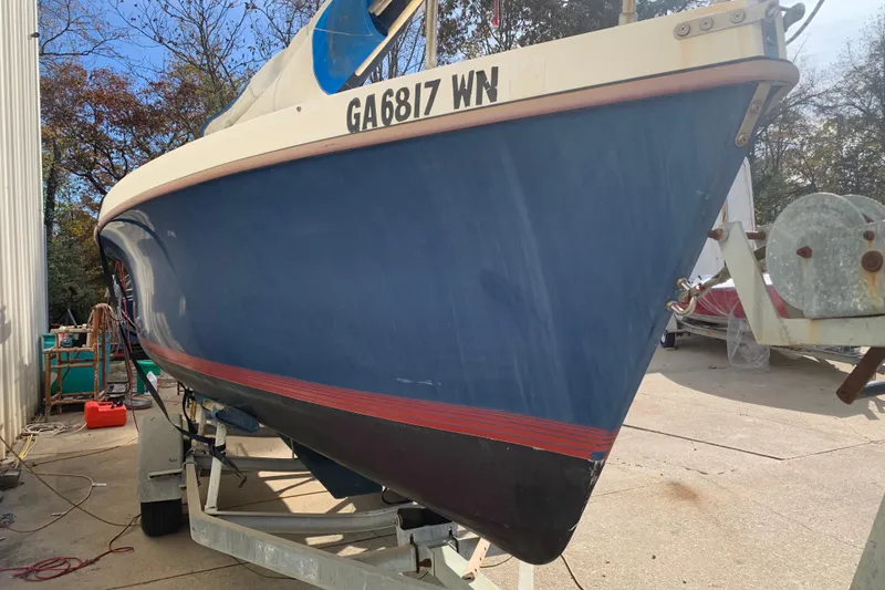 Slide: The Image of 1986 Rhodes 22 sailboat on trailer, blue hull, red stripe, registration GA6817WN. - 2