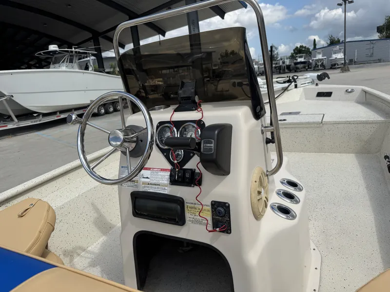 Slide: The Image of 2012 Xpress XP20CC boat console with steering wheel and gauges, docked under a canopy. - 10