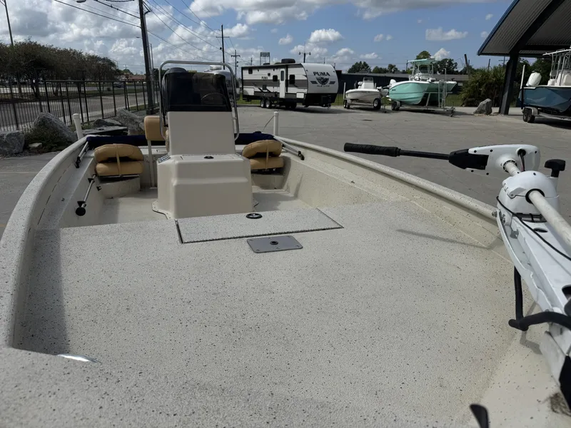 Slide: The Image of 2012 Xpress XP20CC boat with spacious deck and seating, parked outdoors. - 13