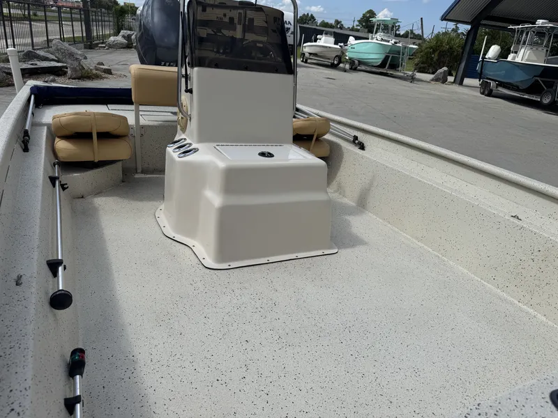 Slide: The Image of 2012 Xpress XP20CC boat interior with console and seating, parked in a marina. - 14