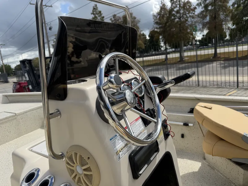 Slide: The Image of 2012 Xpress XP20CC boat console with steering wheel and beige seating. - 16