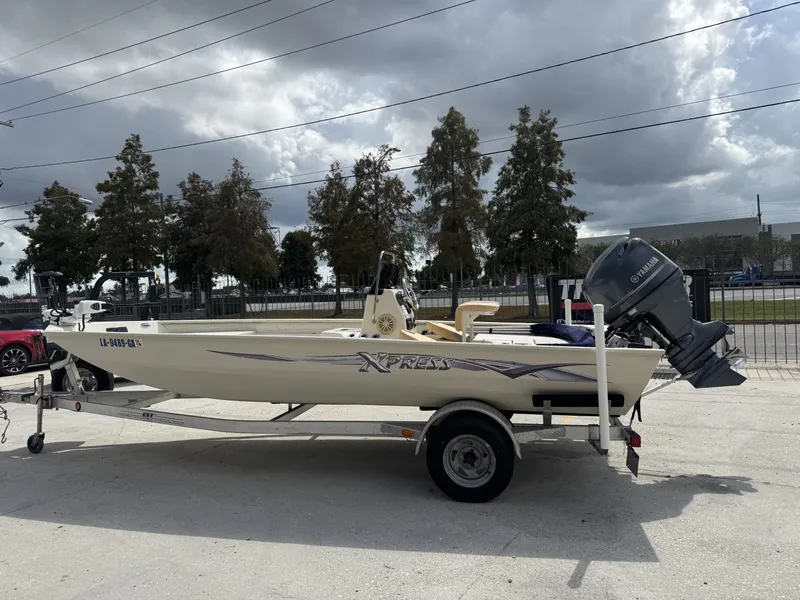 Slide: The Image of 2012 Xpress XP20CC boat on trailer with Yamaha outboard motor, parked outdoors. - 5