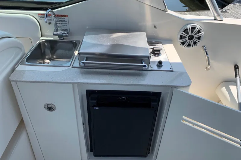 Slide: The Image of 2010 Sea Ray 300 SLX boat kitchenette with sink, grill, and mini fridge. - 15