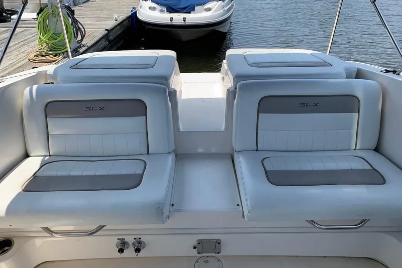 Slide: The Image of 2010 Sea Ray 300 SLX boat interior with white and gray seating at dock. - 18
