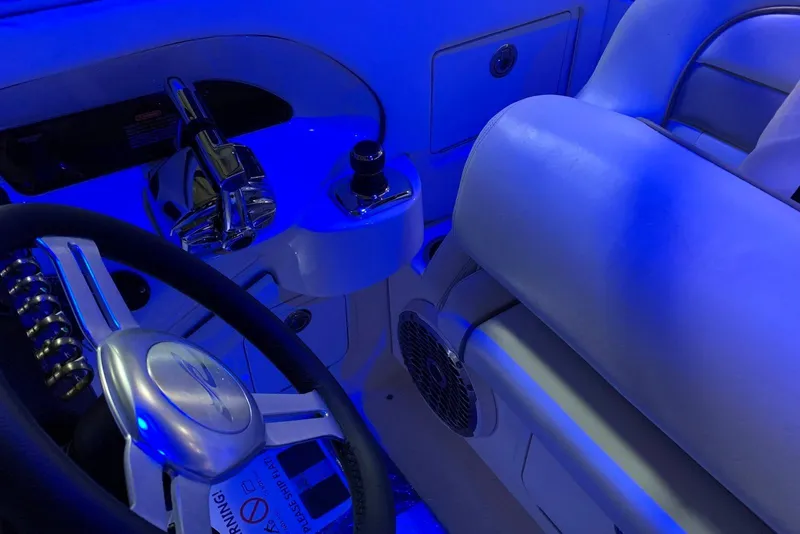 Slide: The Image of 2010 Sea Ray 300 SLX boat interior with blue lighting, featuring steering wheel and controls. - 20