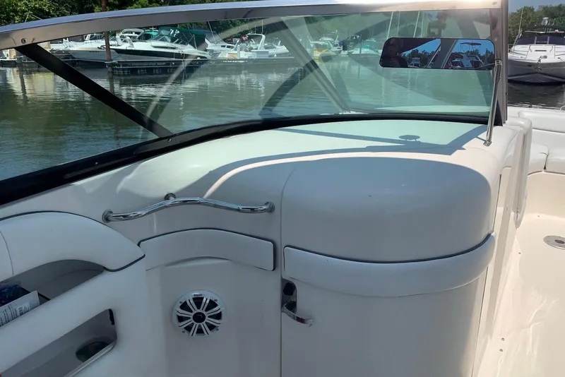 Slide: The Image of 2010 Sea Ray 300 SLX boat interior with windshield and seating, docked at marina. - 9