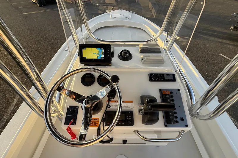 Slide: The Image of 2024 Parker 1801 Center Console boat dashboard with steering wheel and navigation equipment. - 13