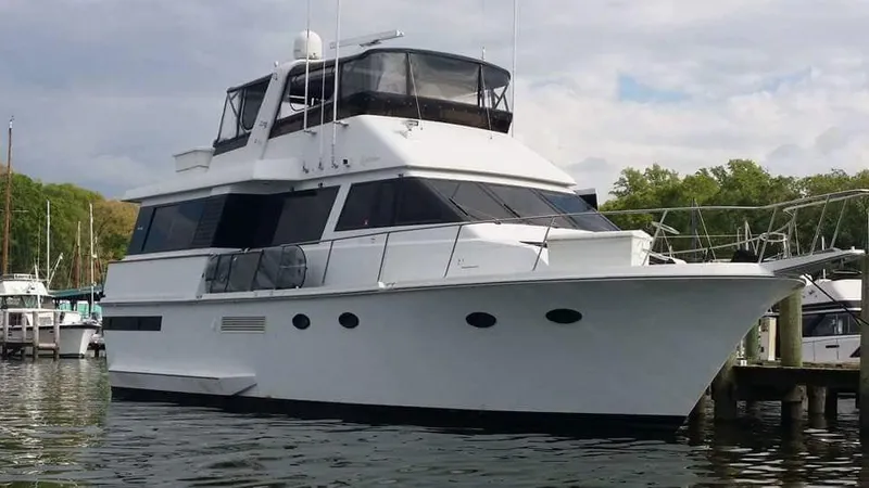 The Image of 1989 Viking 55 Widebody Motor Yacht docked in a marina, showcasing sleek design and spacious deck. - 0