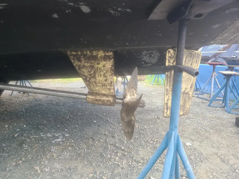 Slide: The Image of 1989 Viking 55 Widebody Motor Yacht underbody with propeller and support stands. - 19