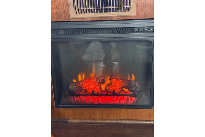 Slide: The Image of Electric fireplace inside 1989 Viking 55 Widebody Motor Yacht, featuring glowing logs and flames. - 26