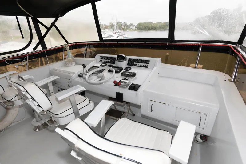 Slide: The Image of 1989 Viking 55 Widebody Motor Yacht interior with seating and dining area, featuring panoramic windows. - 4