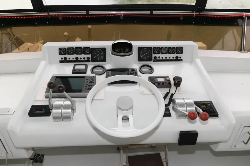 Slide: The Image of 1989 Viking 55 Widebody Motor Yacht helm with three white captain chairs and panoramic windows. - 5
