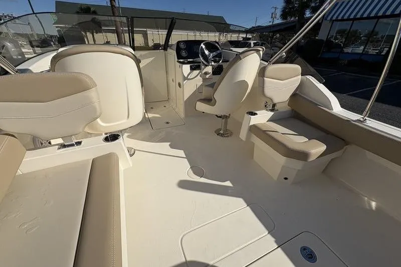 Slide: The Image of 2026 Scout 222 Dorado boat interior with beige seating and steering console. - 13