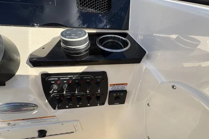 Slide: The Image of 2026 Scout 222 Dorado boat dashboard with controls and cup holder. - 19