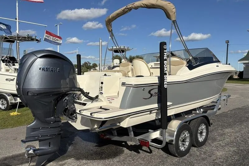 Slide: The Image of 2026 Scout 222 Dorado boat with Yamaha engine on a trailer, under clear skies. - 3