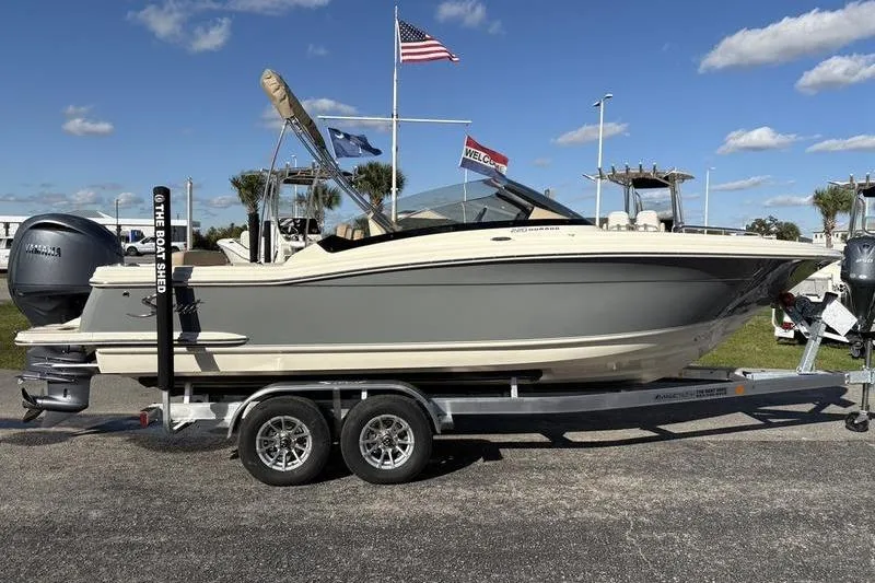 Slide: The Image of 2026 Scout 222 Dorado boat on trailer, displayed outdoors under clear sky. - 4