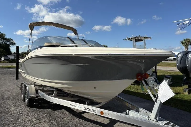 Slide: The Image of 2026 Scout 222 Dorado boat on trailer under clear blue sky. - 5