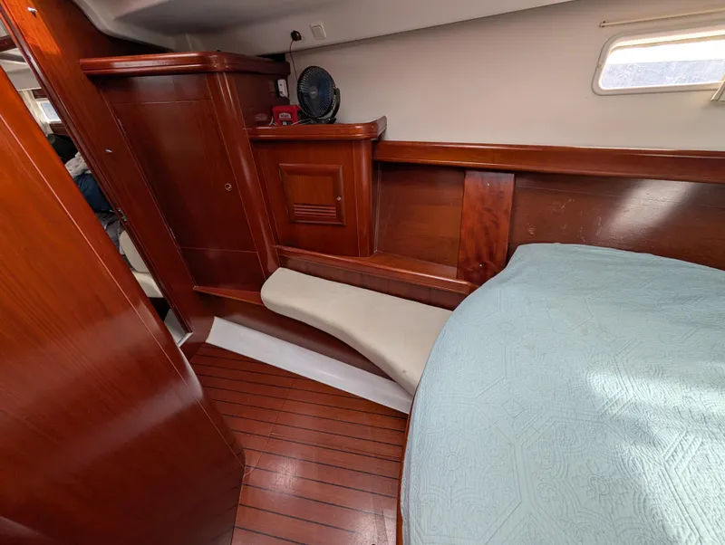 Slide: The Image of 2003 Beneteau Oceanis 473 cabin interior with wooden finish and bed. - 10