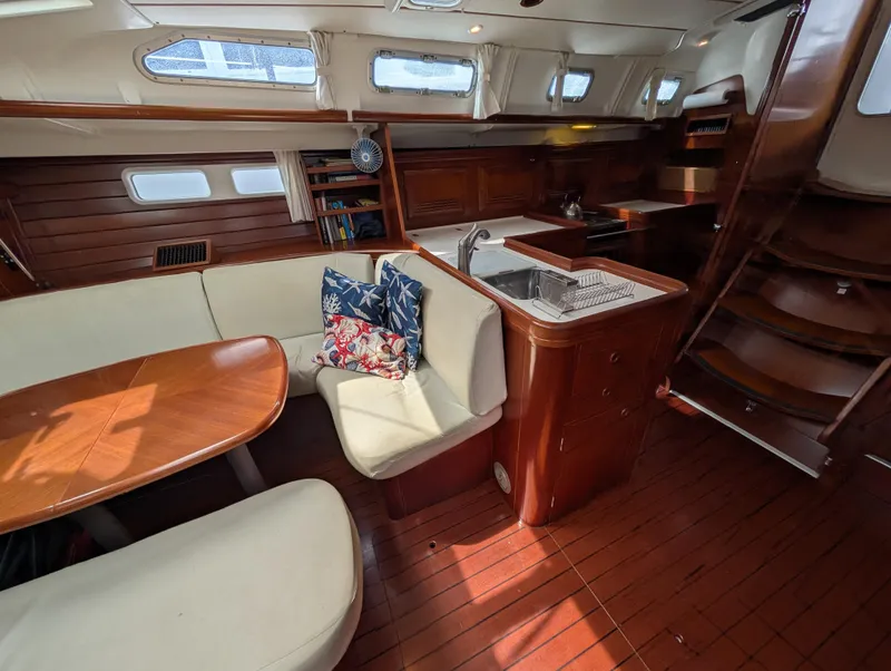 Slide: The Image of 2003 Beneteau Oceanis 473 yacht interior with wooden finish, dining area, and kitchen. - 12