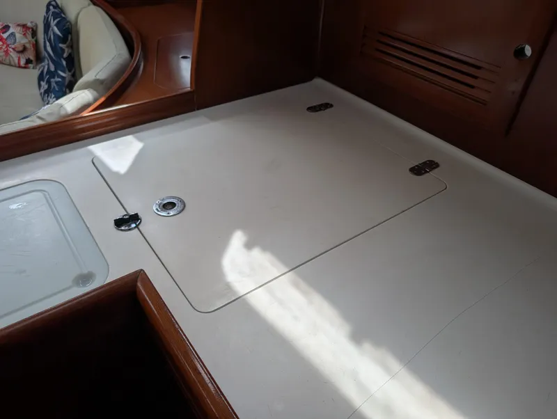 Slide: The Image of Interior of 2003 Beneteau Oceanis 473 yacht, featuring a sleek wooden finish and storage compartment. - 17