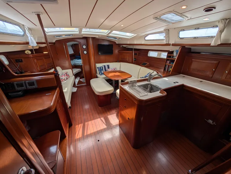 Slide: The Image of Interior of 2003 Beneteau Oceanis 473 yacht with wood finish and spacious seating area. - 2