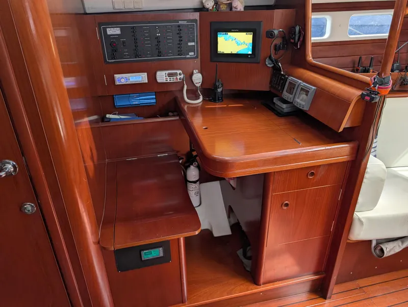 Slide: The Image of Navigation station of 2003 Beneteau Oceanis 473 yacht with control panels and seating. - 20