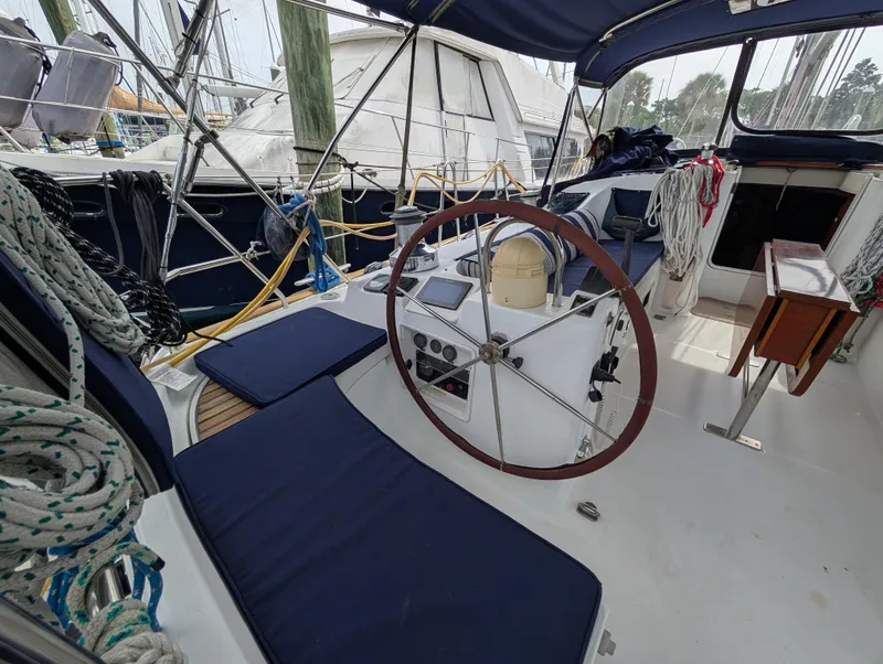 Slide: The Image of 2003 Beneteau Oceanis 473 sailboat cockpit with steering wheel and blue seating. - 31