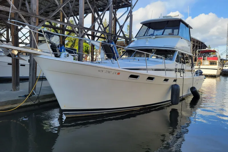 The Image of 1989 Bayliner 3888 Motoryacht docked in a marina, reflecting on calm water. - 1