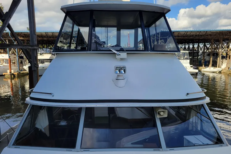 Slide: The Image of 1989 Bayliner 3888 Motoryacht docked at marina, front view with clear sky. - 10
