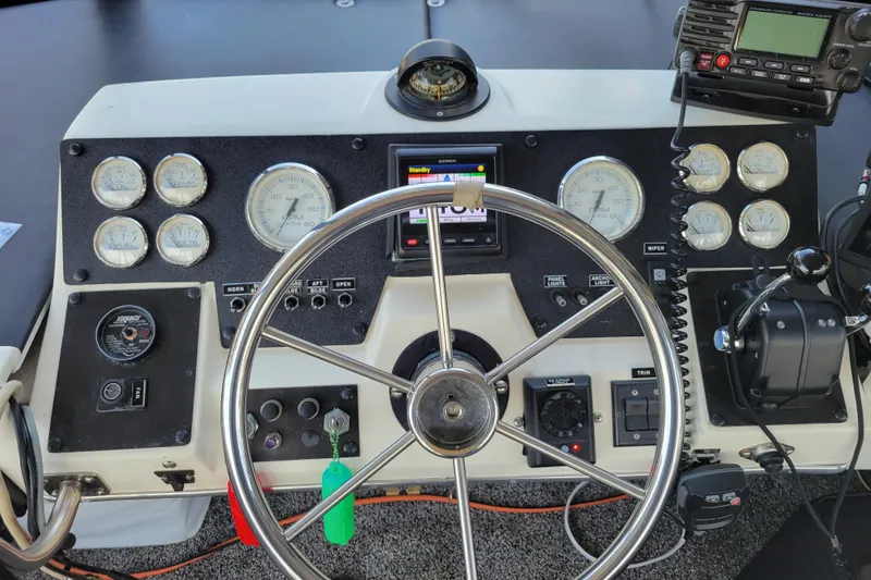 Slide: The Image of 1989 Bayliner 3888 Motoryacht helm with gauges, steering wheel, and navigation equipment. - 14