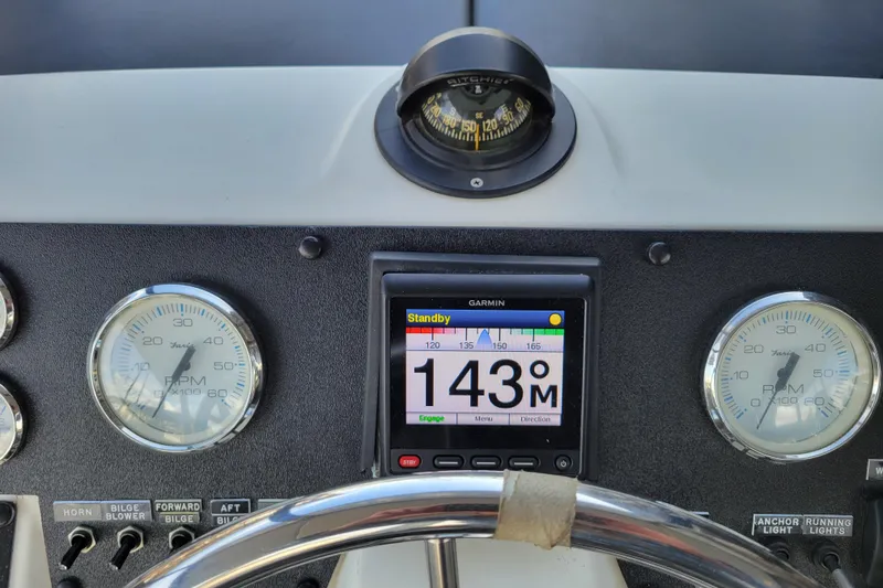 Slide: The Image of 1989 Bayliner 3888 Motoryacht dashboard with compass, Garmin display, and RPM gauges. - 15
