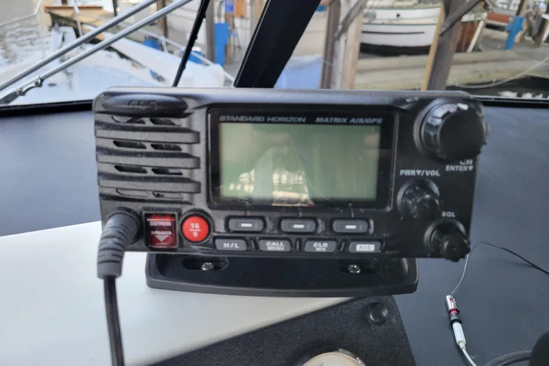 Slide: The Image of Marine radio on 1989 Bayliner 3888 Motoryacht dashboard, featuring distress and channel controls. - 17