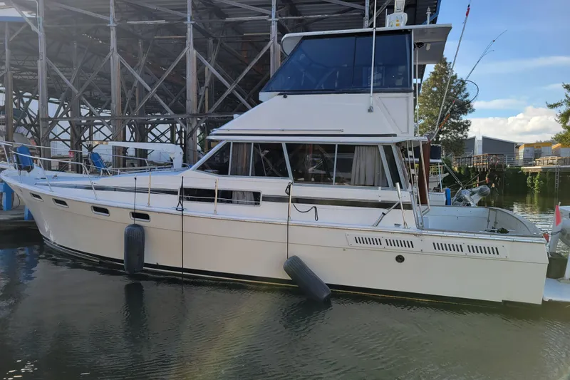 Slide: The Image of 1989 Bayliner 3888 Motoryacht docked in a marina, side view. - 3