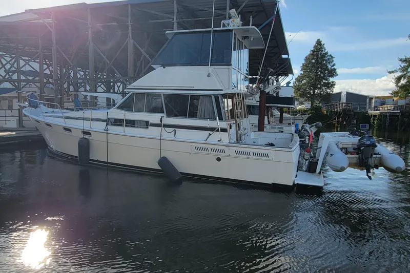 Slide: The Image of 1989 Bayliner 3888 Motoryacht docked in a marina, reflecting sunlight on water. - 4