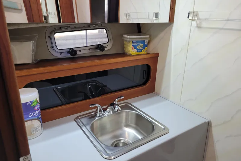 Slide: The Image of 1989 Bayliner 3888 Motoryacht bathroom sink with storage and cleaning supplies. - 41