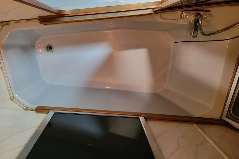 Slide: The Image of Bathtub in 1989 Bayliner 3888 Motoryacht, featuring a sleek, white design with wood accents. - 42