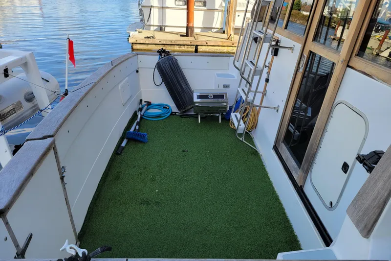 Slide: The Image of 1989 Bayliner 3888 Motoryacht deck with artificial grass, ladder, and docked at marina. - 8
