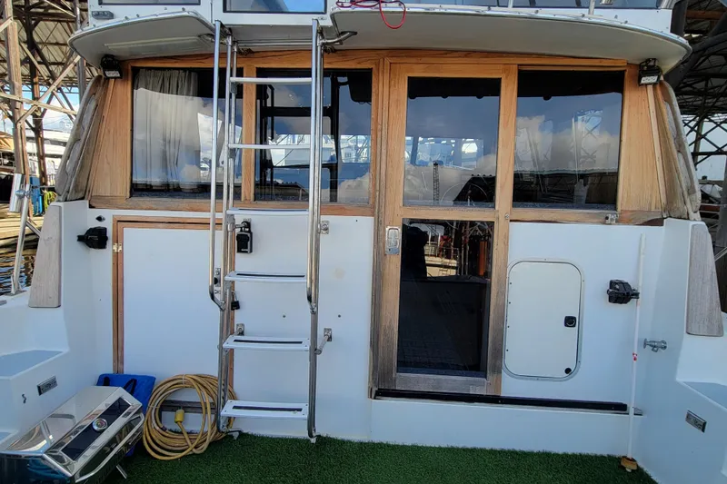 Slide: The Image of 1989 Bayliner 3888 Motoryacht stern view with ladder and glass doors. - 9